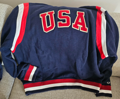 Part of the Polo Ralph Lauren Team USA Collection, this unisex layer reimagines the legendary designer's classic baseball jacket through a vintage lens.  It features an archival Team USA shield patch with the Olympic Rings, which was originally worn by US competitors from 1924 until the ’50s.  Orders for this product will ship 9/14/24.  Expedited orders can be shipped as soon as possible, for an additional $100.