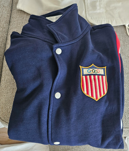 Part of the Polo Ralph Lauren Team USA Collection, this unisex layer reimagines the legendary designer's classic baseball jacket through a vintage lens.  It features an archival Team USA shield patch with the Olympic Rings, which was originally worn by US competitors from 1924 until the ’50s.  Orders for this product will ship 9/14/24.  Expedited orders can be shipped as soon as possible, for an additional $100.