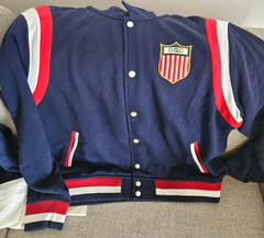 Part of the Polo Ralph Lauren Team USA Collection, this unisex layer reimagines the legendary designer's classic baseball jacket through a vintage lens.  It features an archival Team USA shield patch with the Olympic Rings, which was originally worn by US competitors from 1924 until the ’50s.  Orders for this product will ship 9/14/24.  Expedited orders can be shipped as soon as possible, for an additional $100.